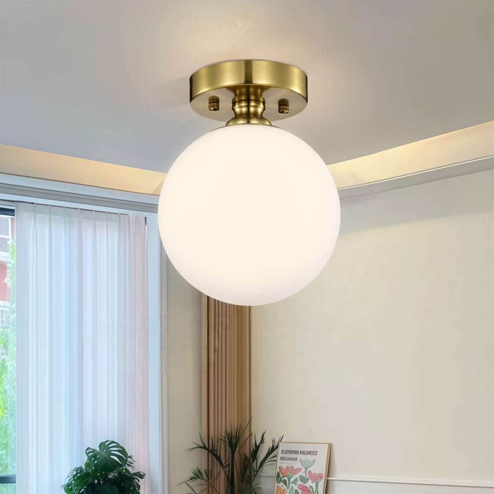 Brass glass globe flush mount ceiling light in a warm hallway
